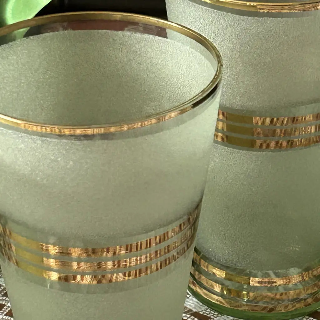 Frosted glasses with gold stripes on a reflective surface